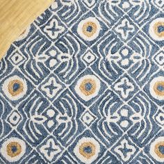 a blue and yellow patterned rug on top of a wooden floor