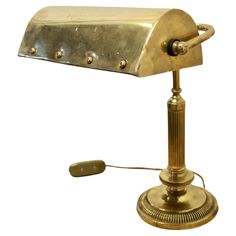 an antique brass desk lamp on a white background