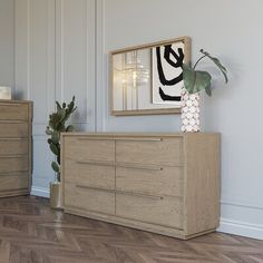 a large wooden dresser sitting on top of a hard wood floor next to a potted plant