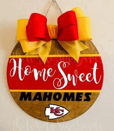 a wooden sign that says home sweet mahomes with two red bows on it