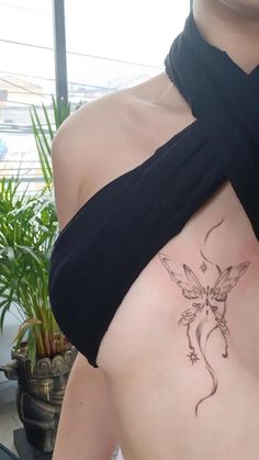 a woman with a tattoo on her back showing the side view of her body and shoulder