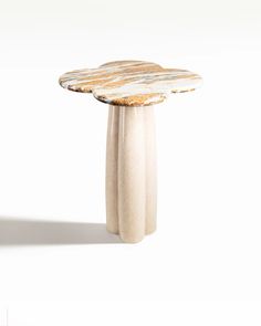 a small white table with three legs and a round top that is shaped like a flower