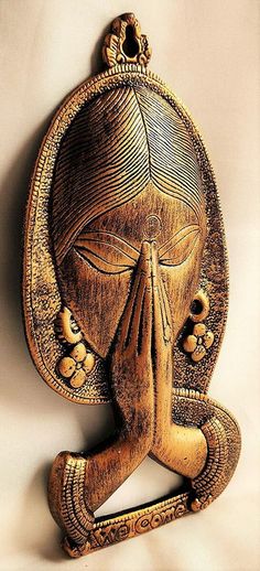 an intricately carved wooden wall hanging depicting a woman's face with her eyes closed