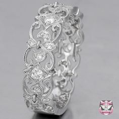 an intricately designed wedding ring with diamonds on the inside and outside, set in 18k white gold