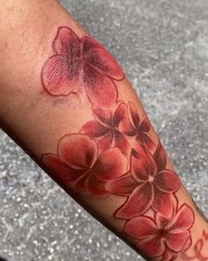 a close up of a person's arm with a flower tattoo on the forearm