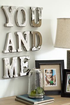 a table with some pictures on it and a lamp in front of the letters that spell out you and me