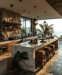 a large kitchen with an island counter and stools in front of the window overlooking the ocean