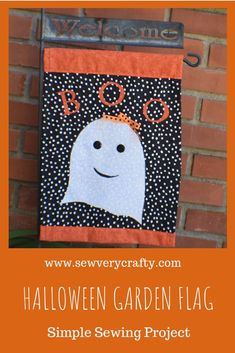 a halloween garden flag hanging on the side of a brick wall with text overlay