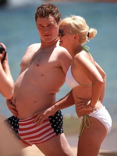 a man and woman in bathing suits on the beach