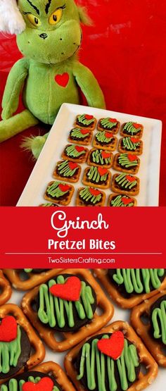 grinch pretzel bites with green frosting and red hearts on them next to a plate of cookies