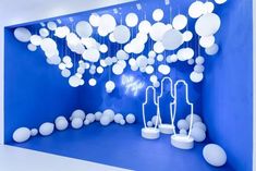 a room filled with white balloons floating from the ceiling