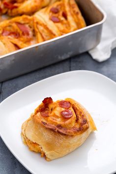 a piece of pizza sitting on top of a white plate next to a baking pan