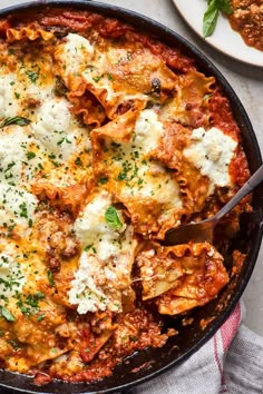 a skillet filled with lasagna sauce and topped with parmesan cheese