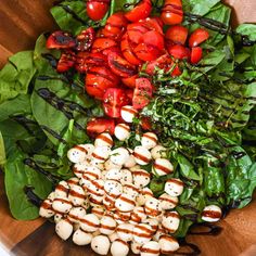 a wooden bowl filled with lots of different types of food on top of each other