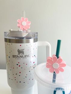 a cup with a straw and a flower on it