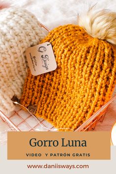 two knitted hats sitting next to each other on top of a white blanket with text that reads gorro luna video y patron crafts