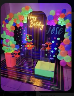 a birthday party with balloons and neon colors on the walls, tables and stools