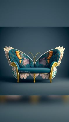 a blue couch with an intricate butterfly design on it's back and arms, sitting in front of a dark background