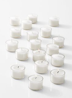 many white candles are arranged on a table