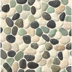 a close up view of some rocks on the ground with white, green and black pebbles