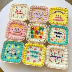 nine decorated birthday cakes sitting on top of a white cake plate with happy birthday written on them