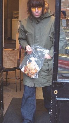 a young man holding a bag of food in front of a door