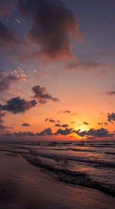 the sun is setting over the ocean with clouds in the sky and waves on the beach