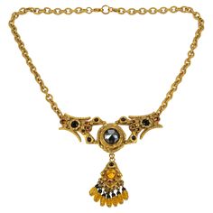 This is a stunning Henry Perichon (aka Henry), Medieval revival gilded bronze pendant necklace. The bronze metal pendant with antique Middle-Age design influences is ornated with faceted French black jet glass cabochons, orange topaz, and yellow citrine crystal rhinestones. Heavy gilded bronze worked chain. The pendant is engraved "Henry Paris" on the back, and the choker has a lobster closing clasp. The necklace is in good condition, with wear on gilded bronze due to regular use. Measurements: Medieval Revival, Claudette Colbert, Black Jet, Bronze Necklace, Bronze Pendant, Bronze Metal, Yellow Citrine, Citrine Crystal, Christian Lacroix