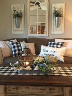 a living room filled with furniture and pillows on top of a coffee table in front of two mirrors