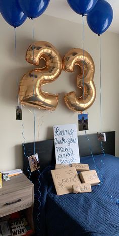 balloons are hanging from the ceiling above a bed with a sign that reads twenty five