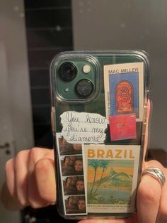 someone is holding up their cell phone case with some pictures and words on the back