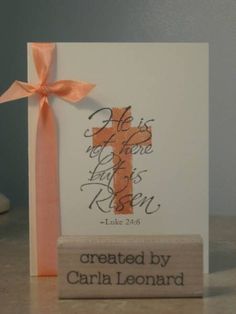 a card with an orange ribbon and a cross on it