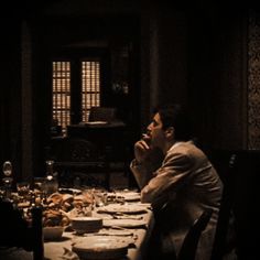 a man sitting at a dinner table in the dark