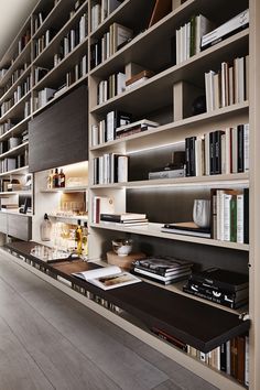 a room filled with lots of books and shelves next to a wall full of books