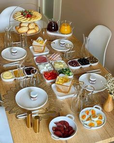 a wooden table topped with lots of plates and bowls filled with different types of food