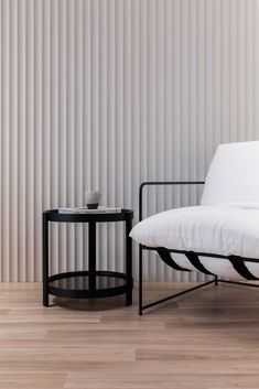 a black and white chair sitting next to a table on top of a hard wood floor