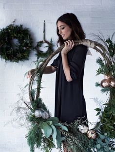 a woman standing in front of a wreath