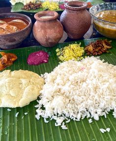 rice and other foods are on a banana leaf