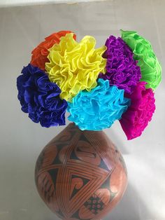 a colorful vase filled with flowers on top of a table