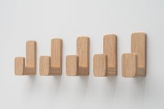 five wooden pegs are lined up on the wall