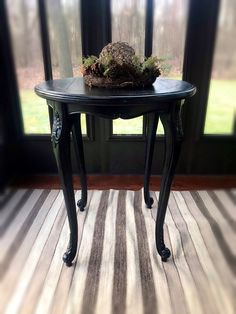 a small black table with a plant on top