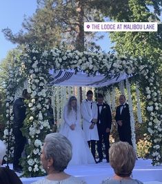 the bride and groom are walking down the aisle at their wedding ceremony in front of an audience