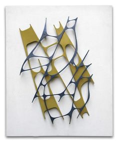 an abstract metal sculpture on a white wall with yellow and black lines in the center