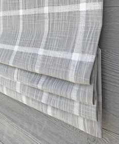 a gray and white checkered curtain hanging on the side of a wooden wall