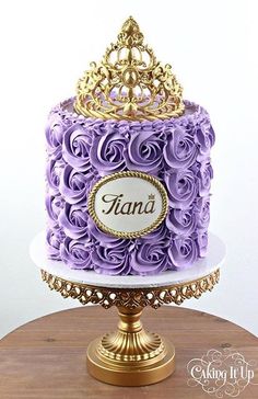 there is a purple cake with gold decorations on the top and nameplates on it