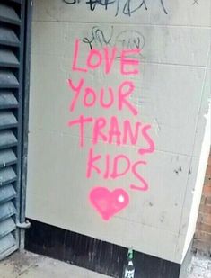 graffiti on the side of a building that says love your transs kids written in pink