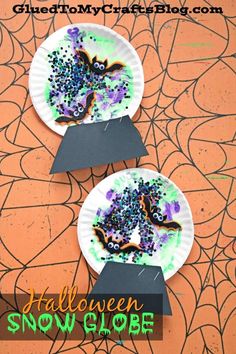 two paper plates decorated with halloween snow globes and sprinkles on them