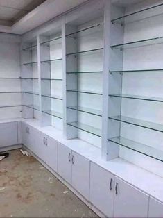 an empty room with shelves and cabinets in the middle of it is being painted white