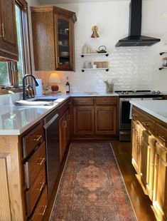 a kitchen with wooden cabinets and an area rug