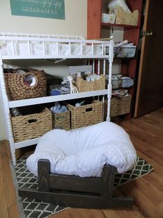 a white bunk bed sitting on top of a wooden floor next to wicker baskets